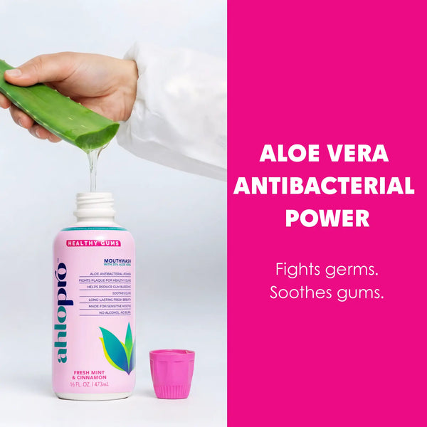Bottle of aloe vera mouthwash with aloe vera gel being poured, on a white and pink background.