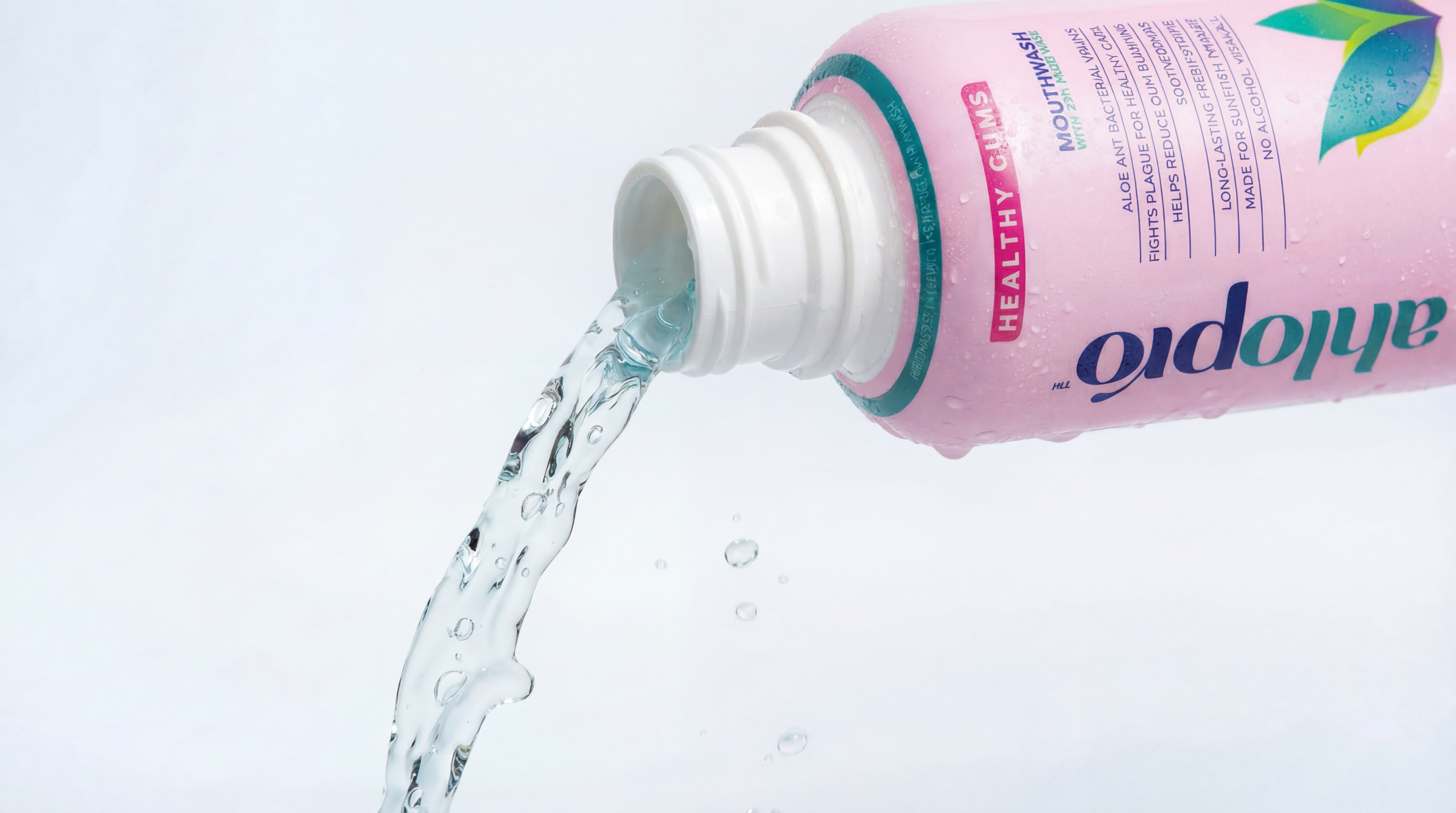 A bottle of Ahlo Pro water being poured on a white background