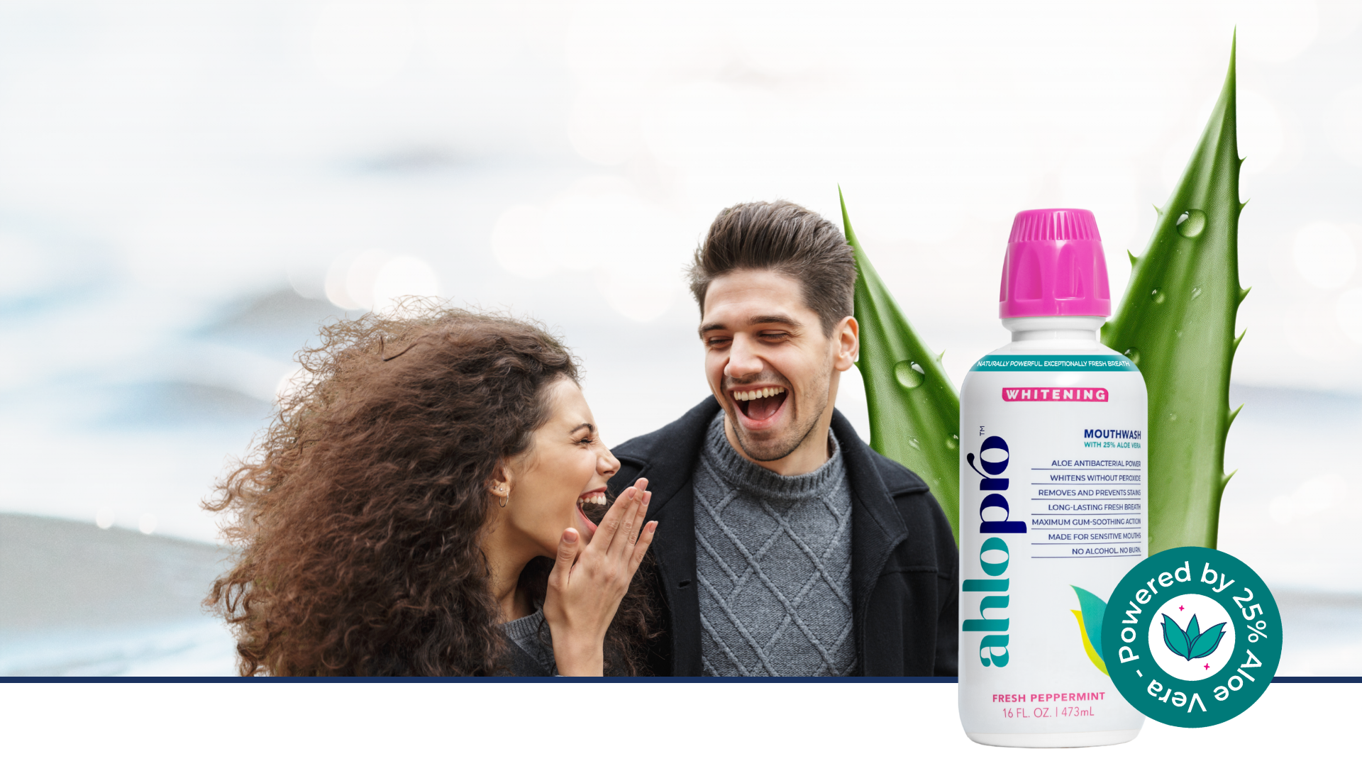 A bottle of ahlopro Whitening mouthwash is shown in the foreground next to a smiling couple and aloe vera leaves. The bottle has a bright pink cap and white and blue label, with a green 'Powered by 25% Aloe Vera' badge on the bottom right.